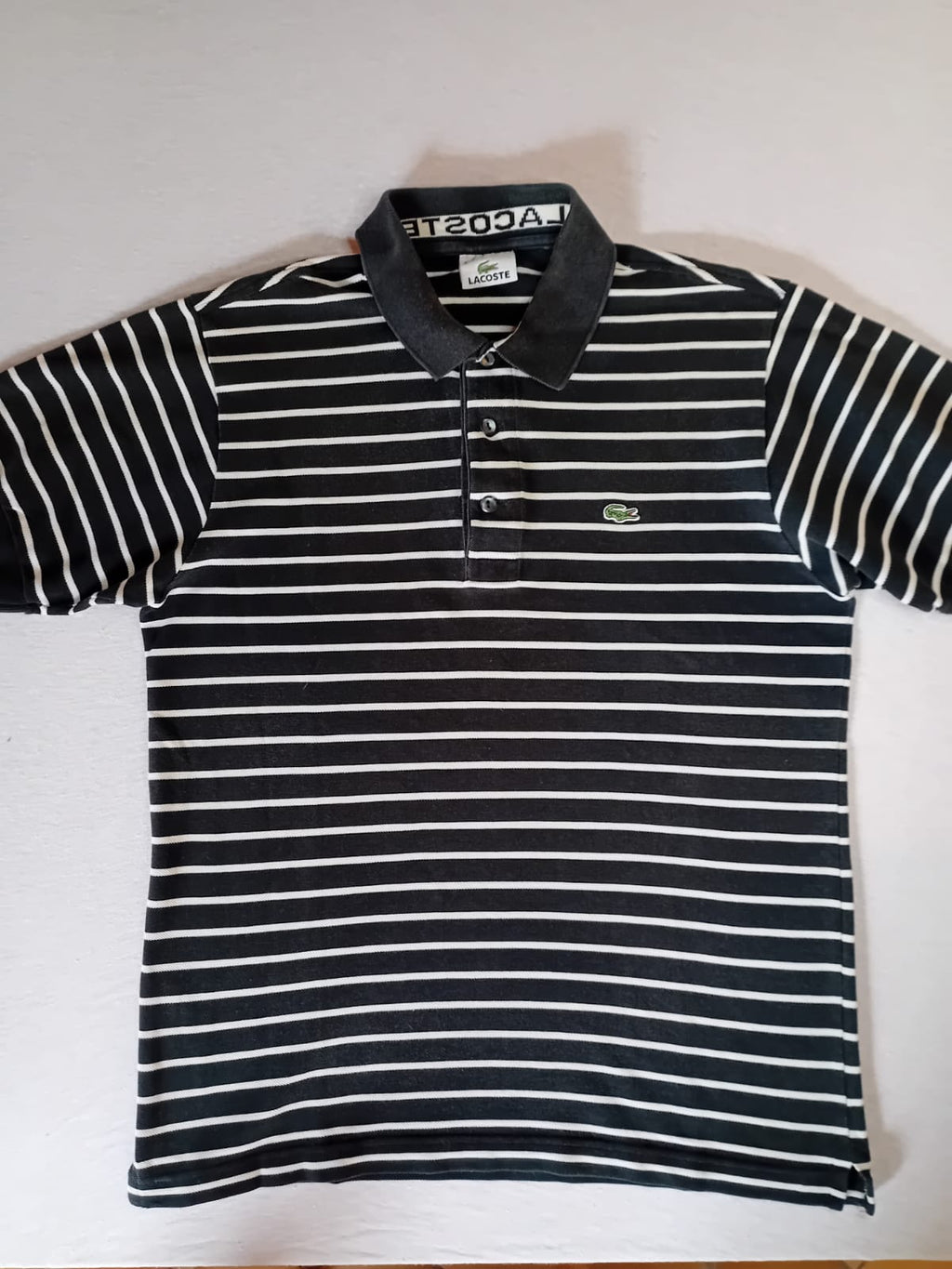 Polo Lacoste fines rayures noir blanc – vue dépliée face